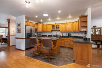 Kitchen is open to the living room with a cozy fireplace and another dining room to the right of this photo.