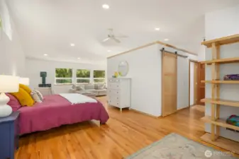 The primary suite is truly a refuge from the world and the rest of the house. Up its own half-flight of stairs, you’ll find total privacy, soothing forest views, a cozy propane stove, and two separate nooks for whatever you desire (currently enjoyed as a seating area and a library/dressing room).
