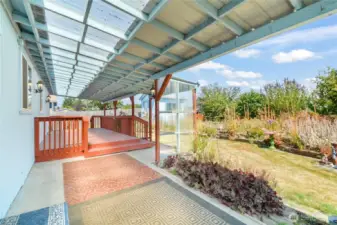 Covered back patio & deck looking out at beautiful garden area