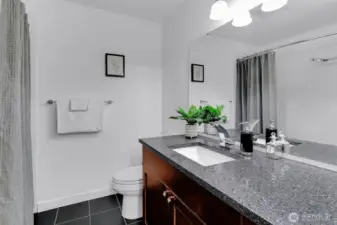 Full bath has also been updated with slab quartz, cherry cabinets and tile flooring.
