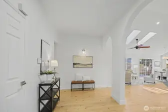 A bright, inviting foyer sets the tone with warm wood floors, soft neutral walls and elegant arched openings leading into the vaulted great room. Recessed lighting and thoughtful accent lighting create a calm, welcoming atmosphere, while open sightlines showcase the home’s architectural character and airy layout. This gracious entry offers a beautiful sense of arrival and flow into the main living spaces.