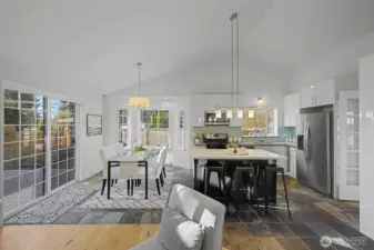 The open kitchen is designed for both function and style, featuring durable quartz countertops, hard-surface cabinetry with a long-lasting finish, stainless steel appliances and a gas cooktop. A spacious center island provides generous prep space and casual seating, making it ideal for everyday living and entertaining.