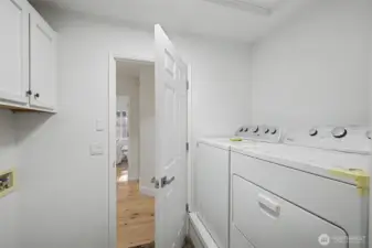 A separate laundry room offers everyday convenience with full-size washer and dryer hookups and overhead cabinet storage for supplies and linens. Clean, bright finishes and easy access from the main living areas make this a practical and well-located utility space that supports effortless daily routines.