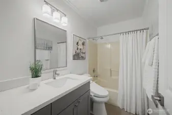 This refreshed guest bathroom features a quartz vanity countertop, modern cabinetry and updated lighting for a clean, contemporary look. A full tub and shower combination provides everyday convenience, while soft neutral finishes and crisp white accents keep the space bright and inviting. Ideal for guests, secondary bedrooms or flexible daily use.