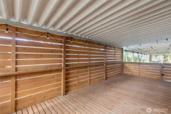 The Deck has been privatized by creating a horizontal cedar slat wall that actually acts as a wind barrier when its cooler outside, a shield when it's raining sideways, a wall that use to hang decor or otherwise, and a visual barrier from the neighboring property.  There are 2 gated access points on either side of the deck; One from the 3-car carport and heading to the storage shed/backyard.
