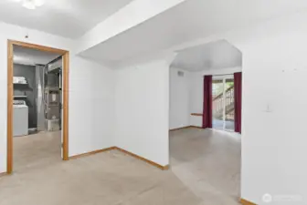 Upon entering the lower level, a central foyer provides access to the utility room, the living room, and the adjoining bedrooms, creating a well-organized and functional layout.