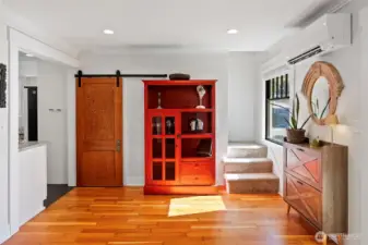 A custom-built barn door has been placed in this area, where the GE washer/dryer combination is tucked behind, allowing for main level living.