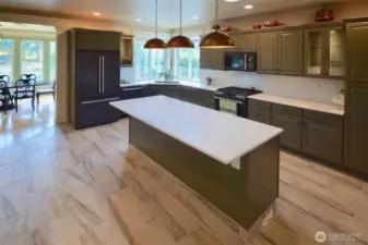 Every detail has been thoughtfully planned in this fabulous kitchen. Three custom copper lights illuminate the impressive quartz island. There's a unique hammered copper kitchen sink and recessed lighting under the cabinetry. The kitchen is equipped with two ovens (gas and electric) for big gatherings and special events.