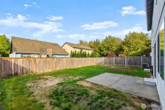 The fenced backyard has lots of room. Notice the a/c unit toward the side of the home.