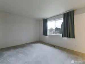 Spacious primary bedroom on back of house.  Overlooks private backyard.  Houses visible are across the street behind the property.