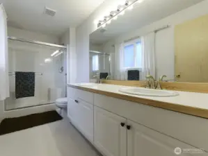 Ensuite primary bath.  Double vanity, privacy film on window lets in natural light.
