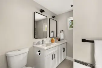 Primary bathroom with custom vanity, dual sinks, Quartz counters and luxury Italian tile floor and shower.