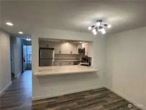 The large dining room is open to the kitchen, creating a seamless flow, and is highlighted by a modern matte black designer light fixture that adds a stylish, contemporary touch to the space.