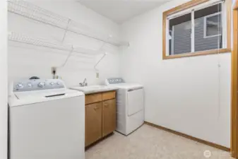 Laundry room features a utility sink and large linen/coat closet.