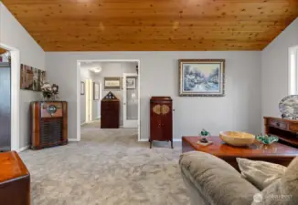 From the living area looking toward the entry and beyond to the hall to the den, bedrooms & stairs to the second floor.