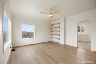 The beautiful, clean front room has floating wood shelves and a quiet fan.