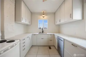 Quartz countertops, tile floor & loads of cabinets