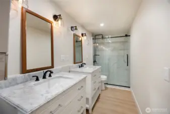 Downstairs updated bathroom. Double marble vanities with lots of storage & beautiful tile shower.