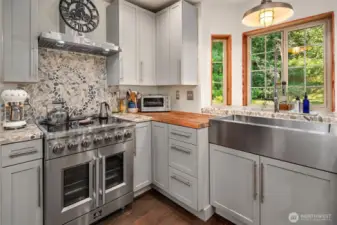 Custom tile work on the wall behind the Forno stove with french doors and enamel interior.