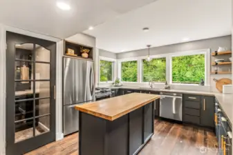 Kitchen w/ mobile island, walk in panty, gas cook cook top/oven, stainless appliances, concrete counters, lots of natural light, newer Anderson windows, NEW dishwasher.