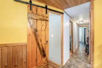 View Down The Hallway To Primary, Starting At Bedroom 3 W/ a Barn Door