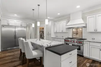 Luxurious slab granite countertops blend seamlessly with the stainless steel appliances, creating a harmonious and upscale kitchen design.
