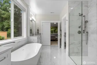 A walk in frameless glass shower is highlighted by floor to ceiling tiling and brushed nickel shower hardware.