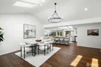 The high ceilings, skylight, and large chandelier fill the space with light, creating an open and bright atmosphere.