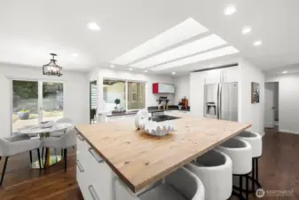 A large island, three skylights large windows with views of the backyard