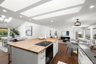 Open-concept living with the kitchen at the center, offering views of both living rooms, the dining area, and the backyard.