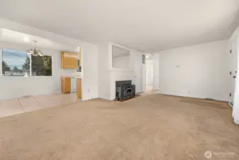 View from NW corner of living room showing dining area, fireplace insert & hallway to full bathroom & bedrooms 1 & 2.