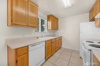 Super clean kitchen includes garbage disposal & dishwasher with a view of the backyard.