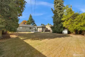 Priviate, fully fenced, level backyard has an outbuilding for storag of lawn tools & equipment.