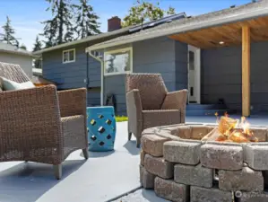 Here, you can gather around a central firepit, its warm glow inviting conversation and relaxation. Low, comfortable seating with neutral-toned cushions surrounds the firepit, offering the perfect spot to unwind and enjoy the serene ambiance.