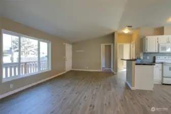 Large living area with eating bar at the kitchen peninsula, in addition to space for a dining table near the utility room.