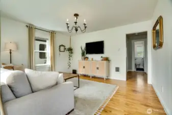 Enter into the main living room. Beautiful and well kept hardwood floors, modernized windows, light fixtures and systems.