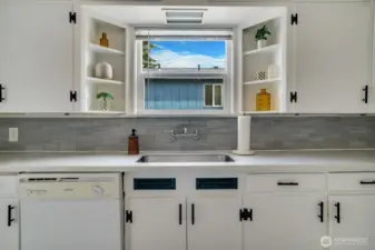 Undercount sink, timeless wall mounted faucet, open shelving and many cabinets for your kitchen gadgets