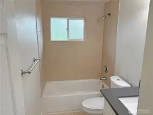 Full bath on the main level of this updated split-level in Cascade, Renton WA 98058—bright, refreshed finishes and a functional layout near the bedroom hallway.