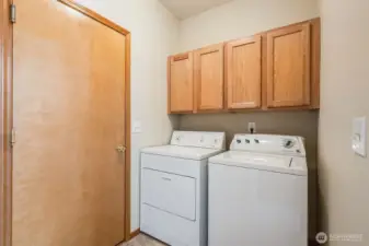 The utility room offers extra storage above the washer and dryer. It's conveniently located next to the garage and kitchen.
