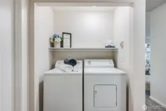 An in-unit washer and dryer stay with the home, tucked into this closet in the hallway.
