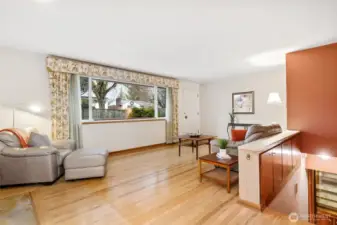 Comfortable living room with hardwoods, wood burning fireplace and built-ins above the stairs.