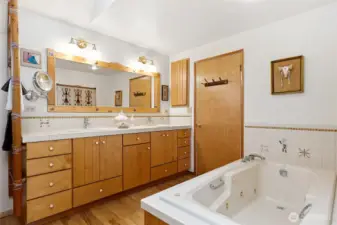 1/2 of large bathroom off primary bedroom includes dual sinks and jetted tub