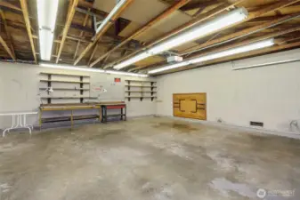 Interior of oversized 2 car garage flanked by 2 car, carports on either side