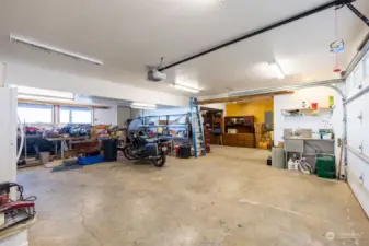 Expansive shop area, room for 4 cars, has generator connection,extra workshop/storage or movie room. Free standing woodstove just inside back door. Shop area has view of the backyard and the bay!