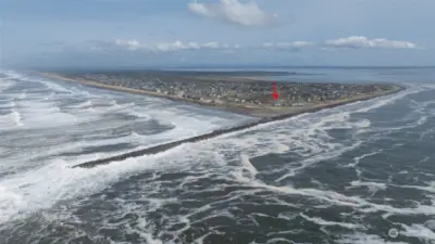 AERIAL IN THE OCEAN SHOWING THE CONDO (RED ARROW) THE JETTY AND BAY IN THE BACKGRO9UND!