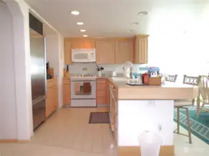 PREPARE GOUMET MEALS IN THIS GORGEOUS KITCHEN WITH TILE FLOORING, CANNED LIGHTING AND STAINLESS STEEL APPLIANCES WHILE VISITING WITH SPECIAL GUESTS WATCHING FROM THE EATING BAR!