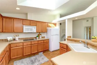 Large kitchen with white refrigerator, dishwasher, microwave and oven.