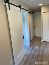 DADU Hallway With Barn Doors To Bedroom & Bathroom. Bifold door to the stacking Laundry.