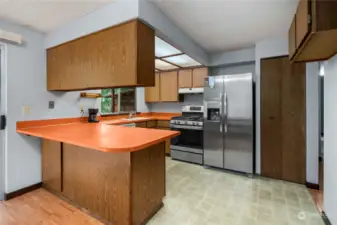 Kitchen with newer stainless steel refrigerator and gas stove.