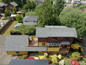 Aerial of the home, sunny deck, and 2 balconies.
